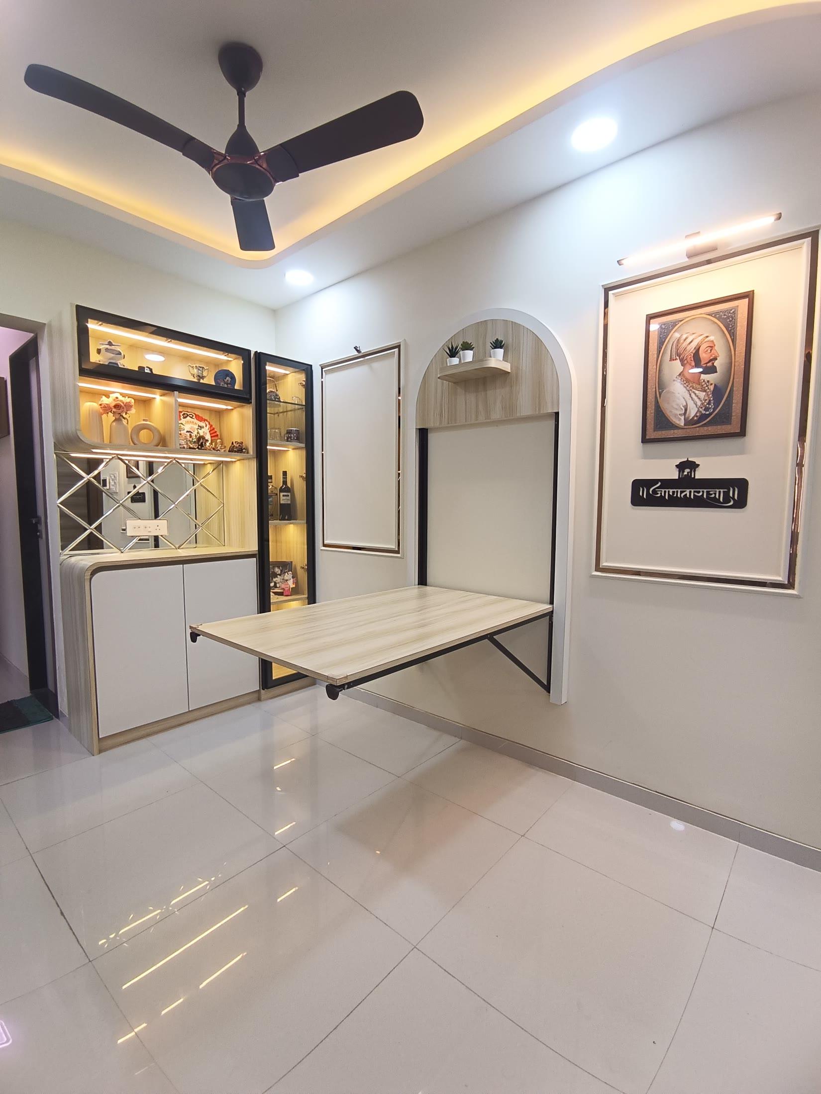 Wider view of the dining corner with the folding table open under a cove ceiling