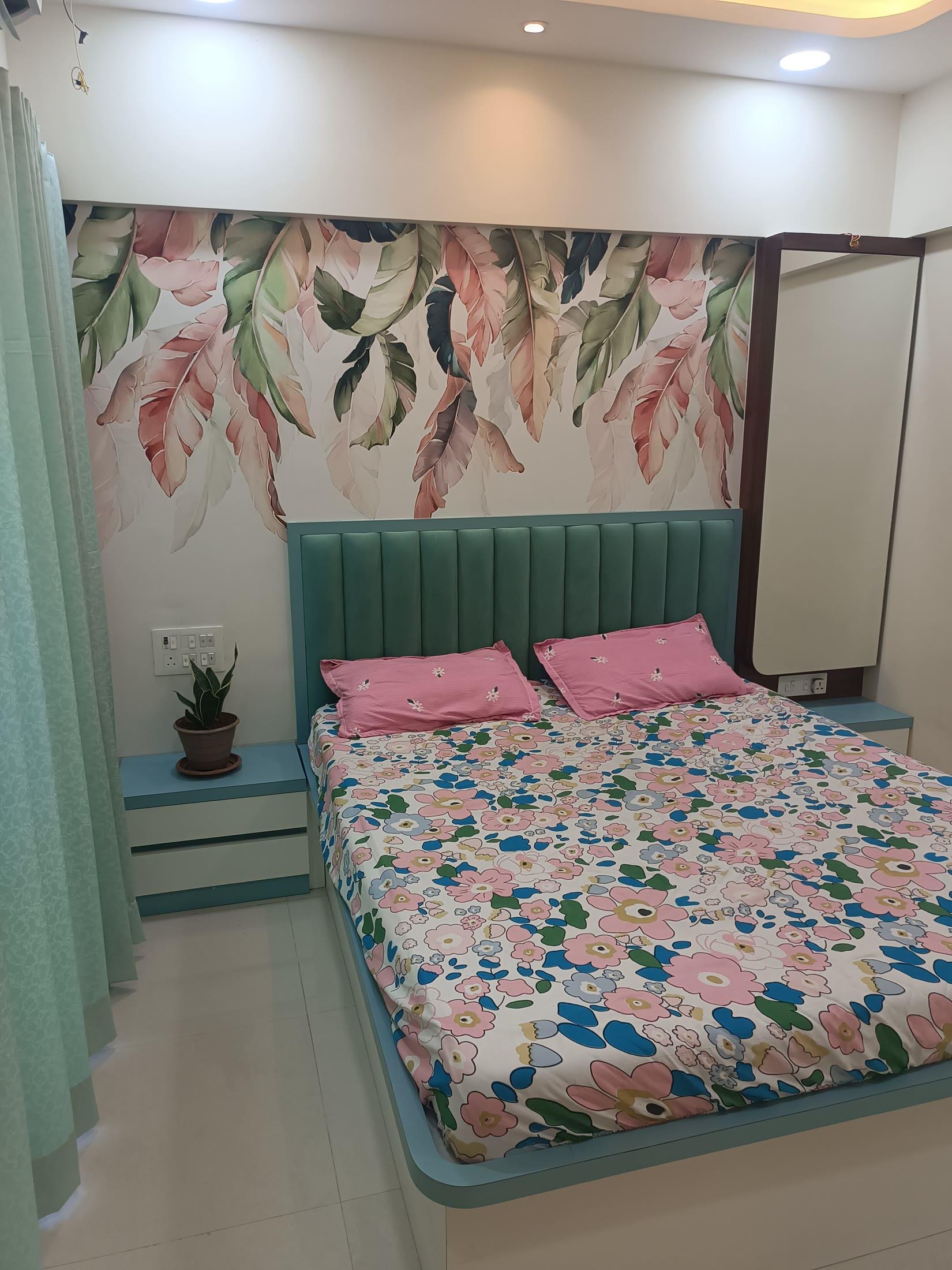 Master bedroom with a painted leaf mural and a fluted teal upholstered headboard