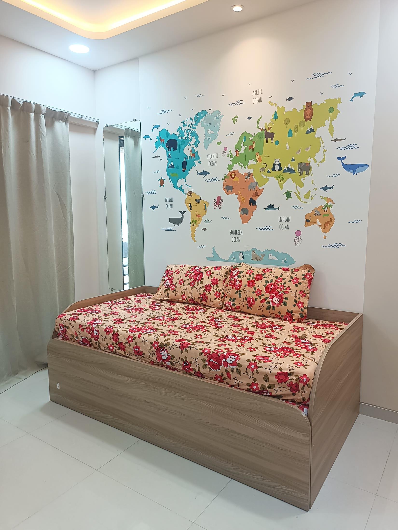 Children's bedroom with a world-map wall and a wooden divan bed