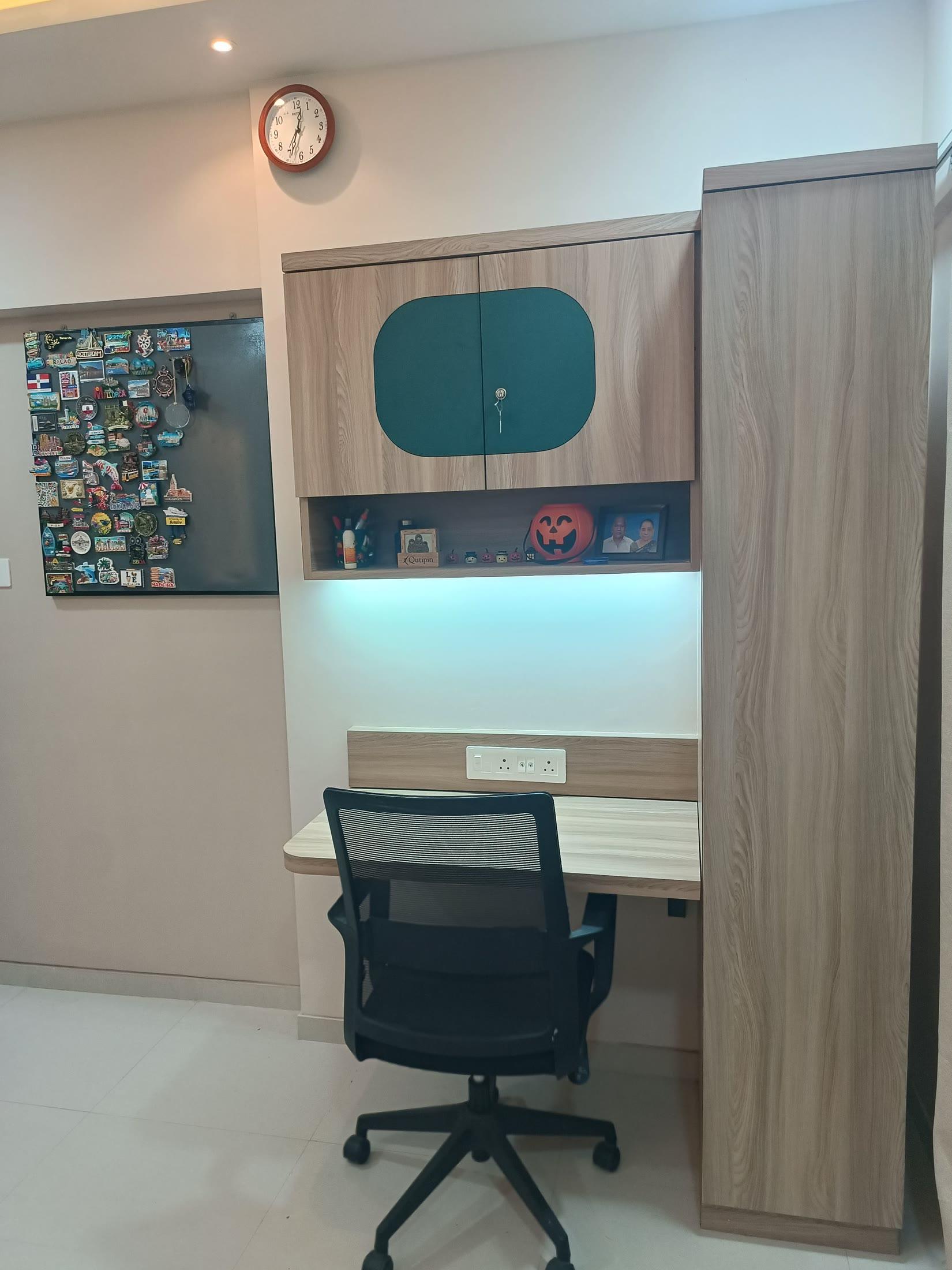 Study niche with a pinboard, wall clock and under-shelf lighting