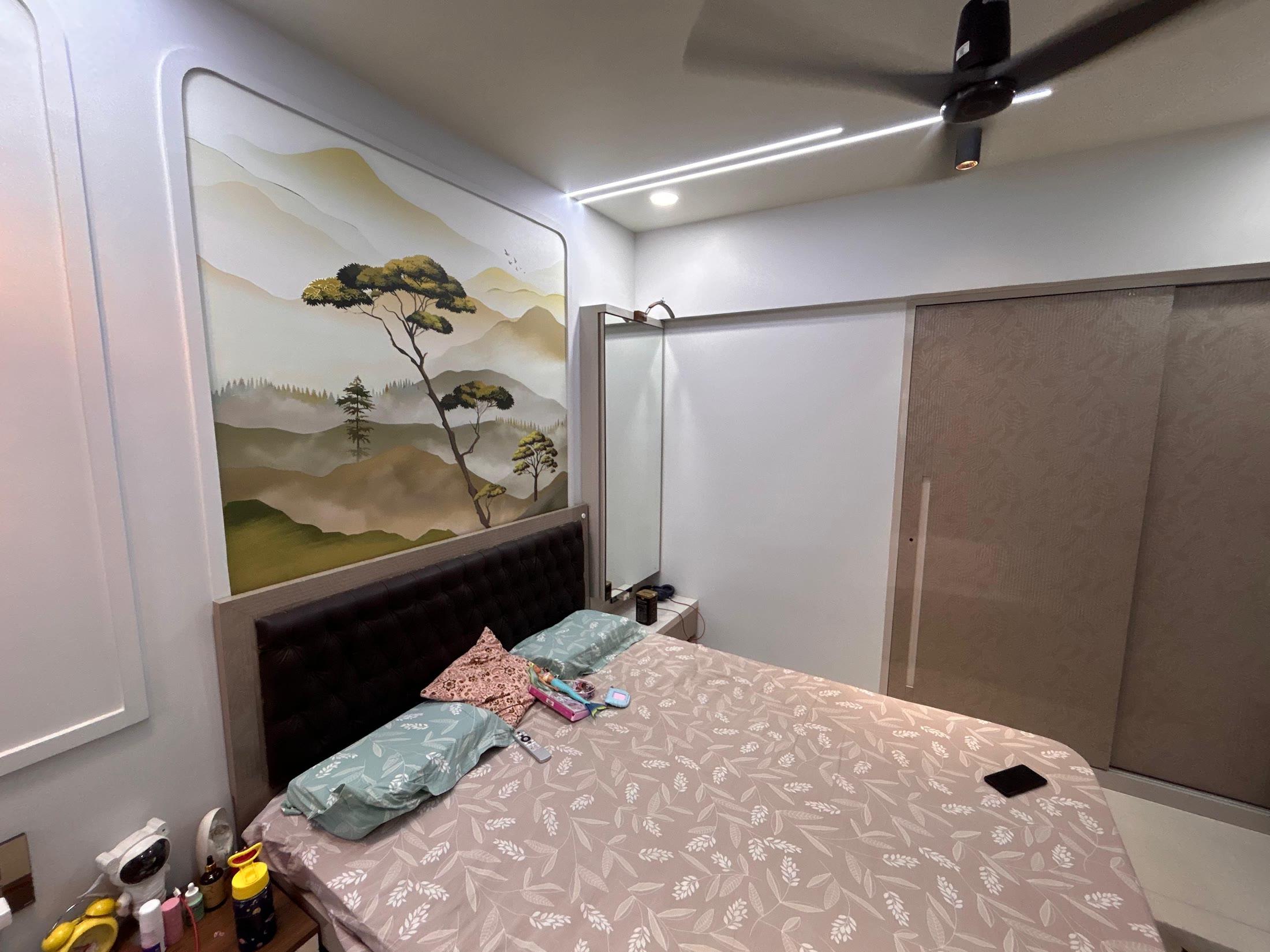 Bedroom with a painted pine-and-mountain mural above a tufted headboard