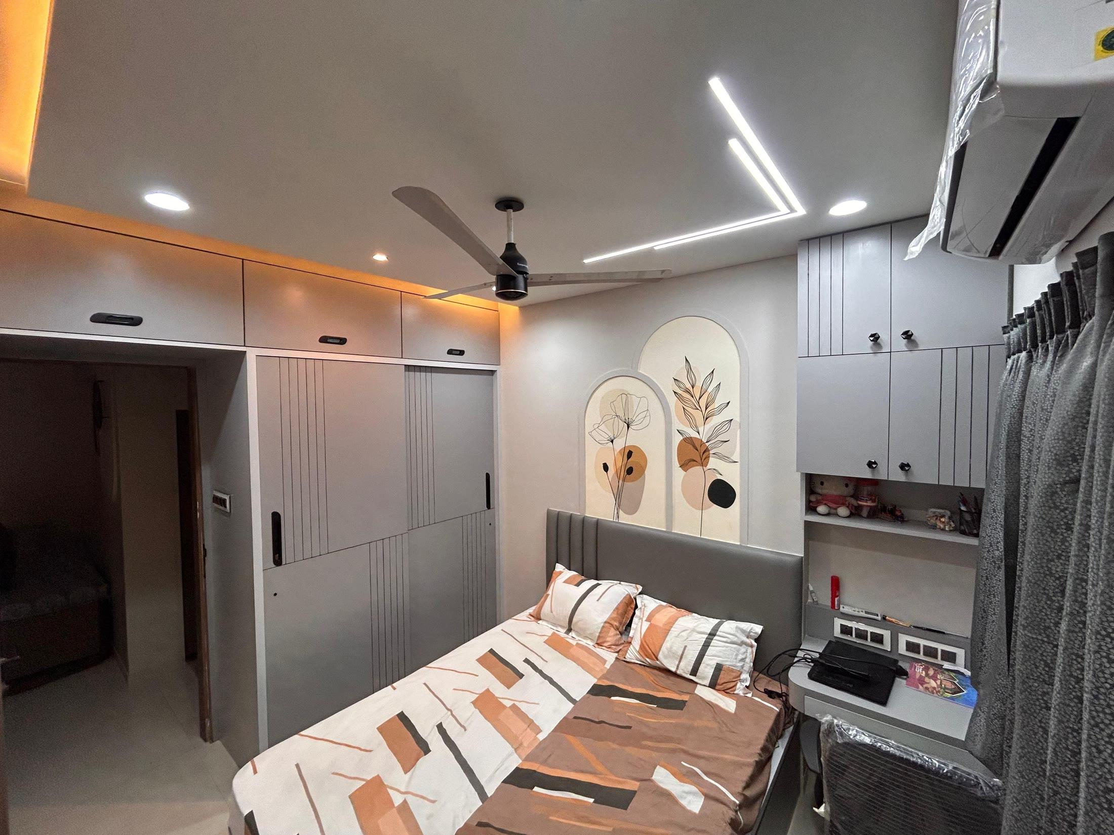 Bedroom seen wide, showing the full wardrobe wall and dresser niche