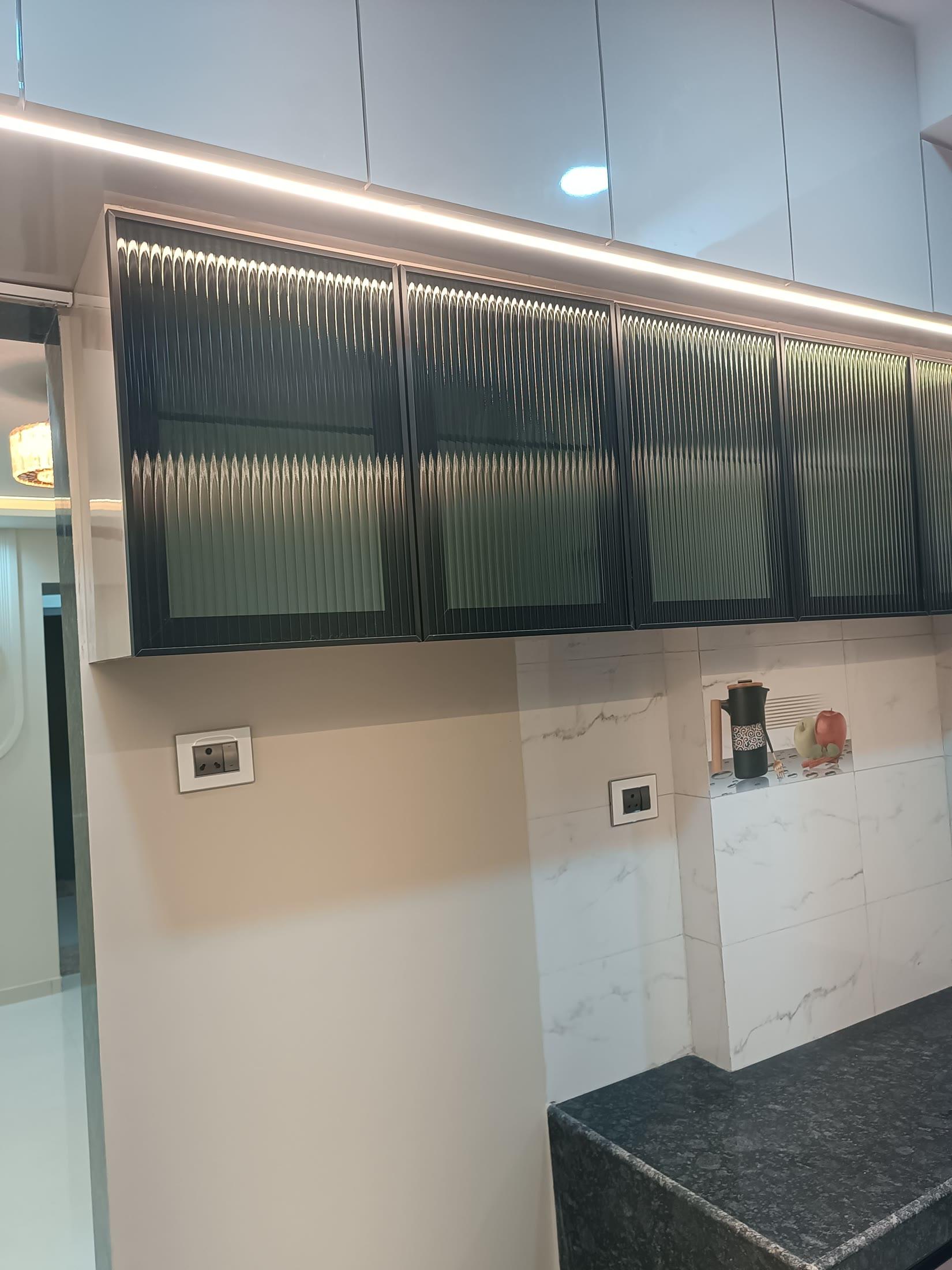 Kitchen run with fluted-glass overhead shutters above a marble dado