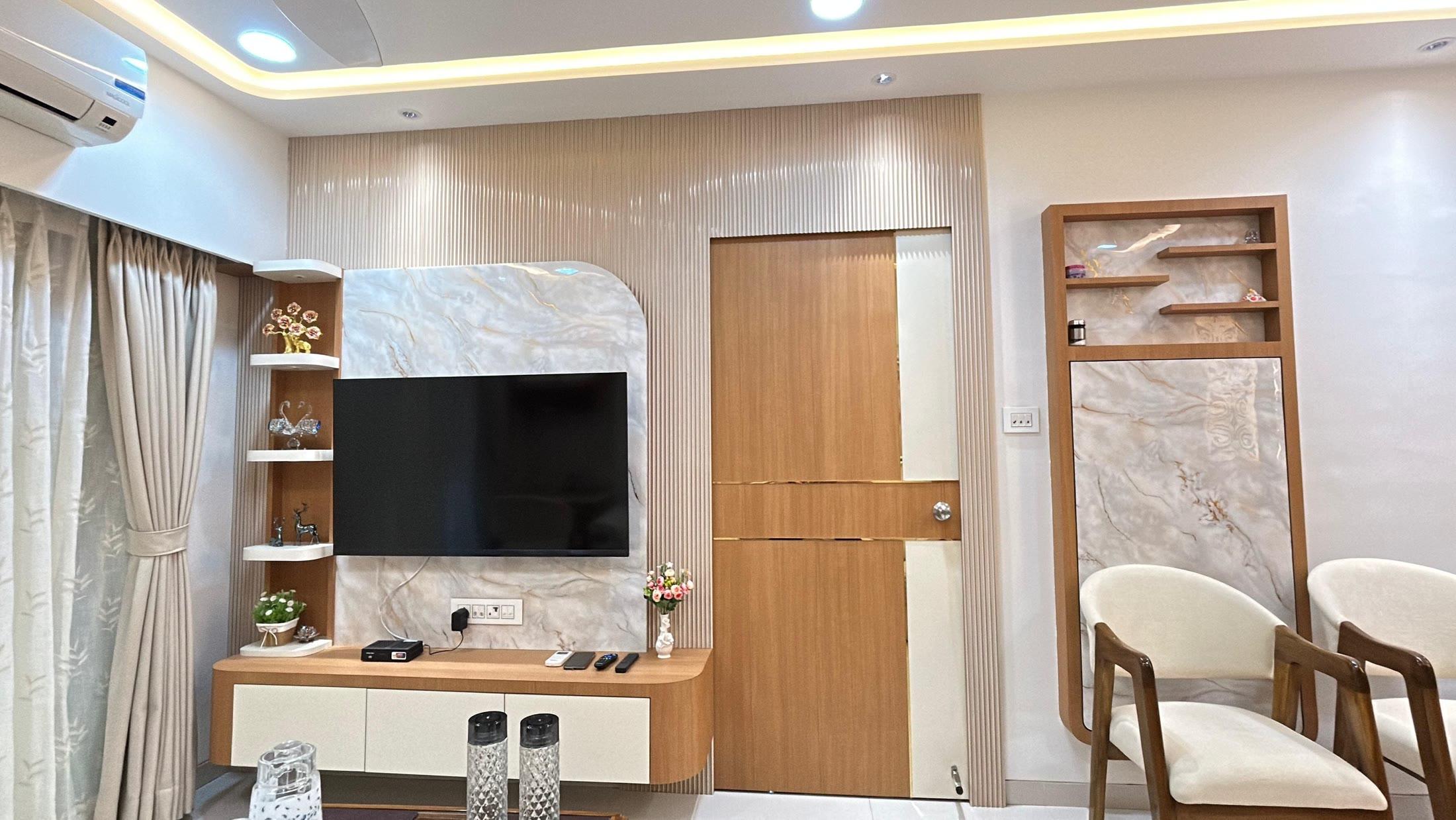 Wide view of the living room with the media wall, teak door and seating