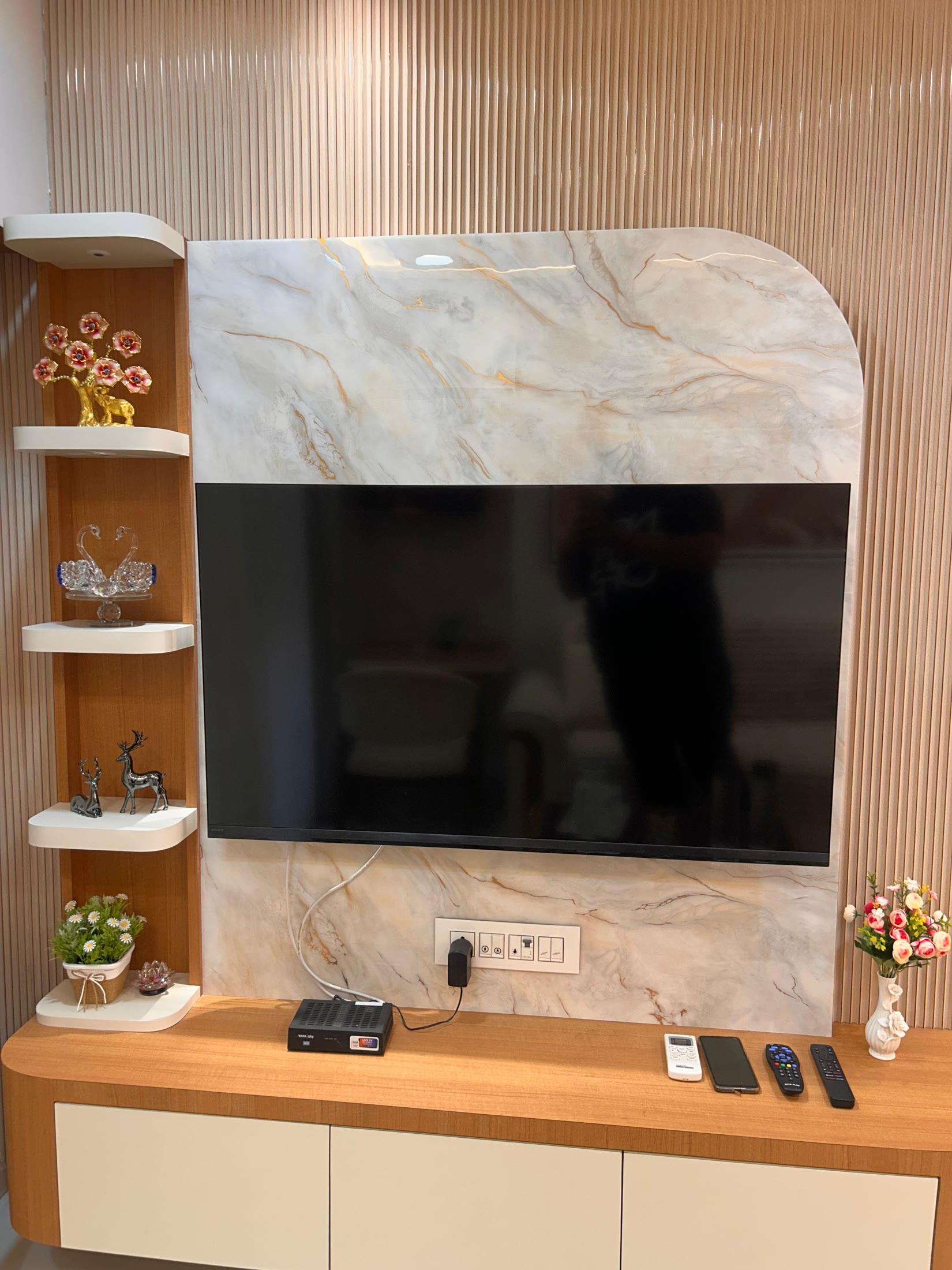 Media wall detail: book-matched marble, fluted teak and lit corner shelves