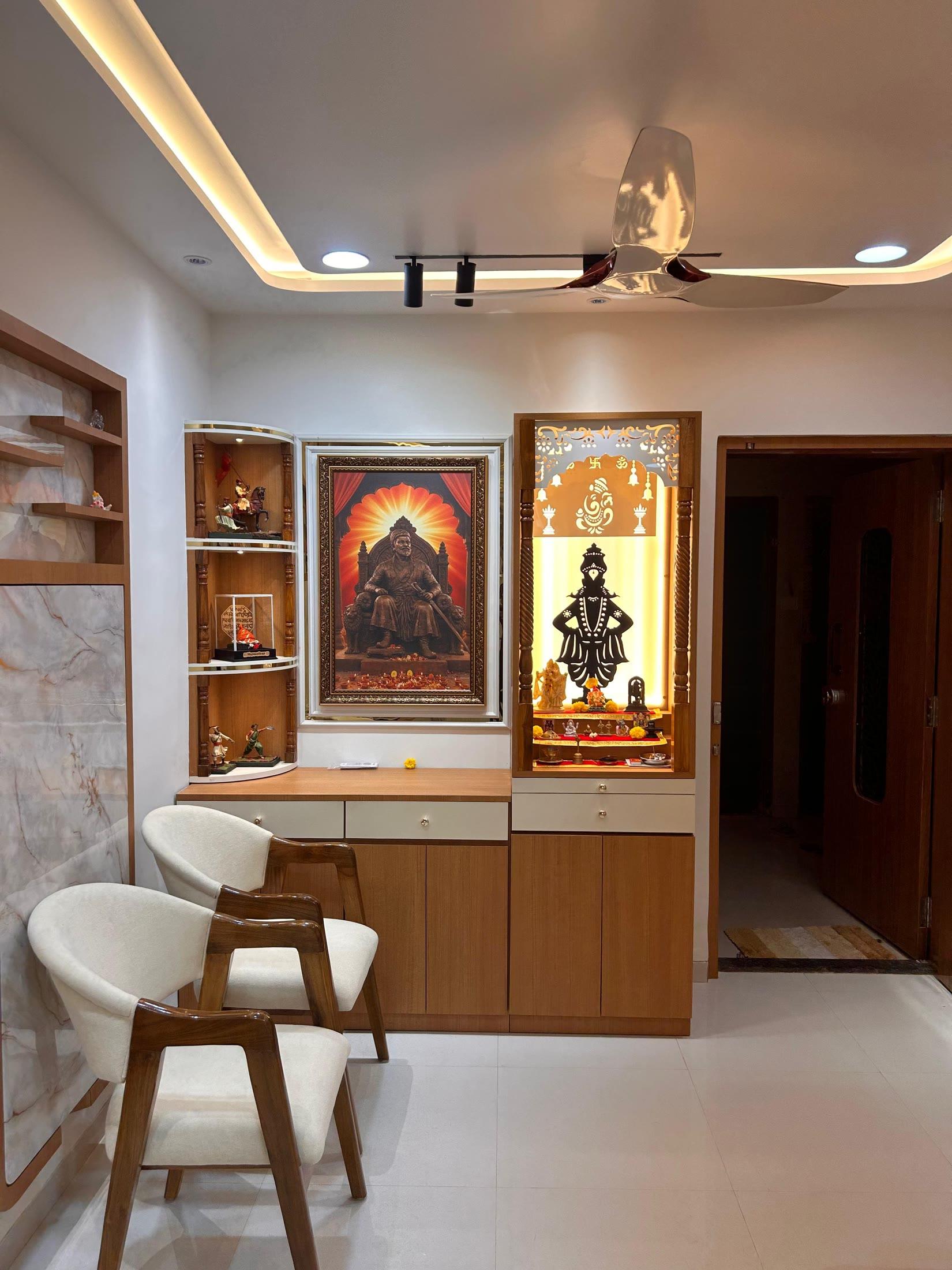 Dining area with a backlit mandir set into a marble and teak wall