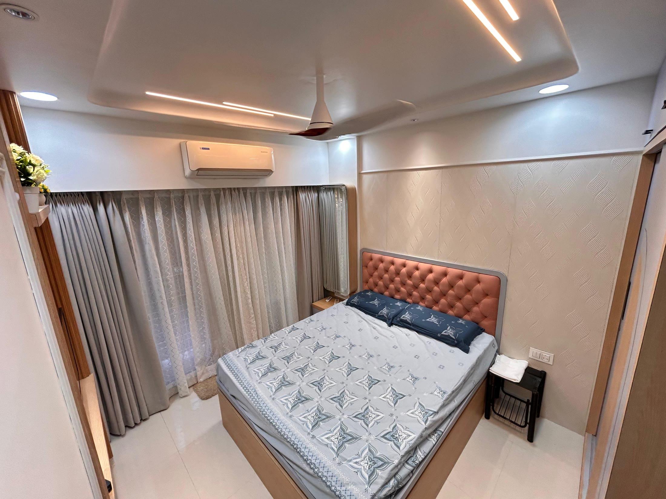Master bedroom with a terracotta tufted headboard and layered curtains