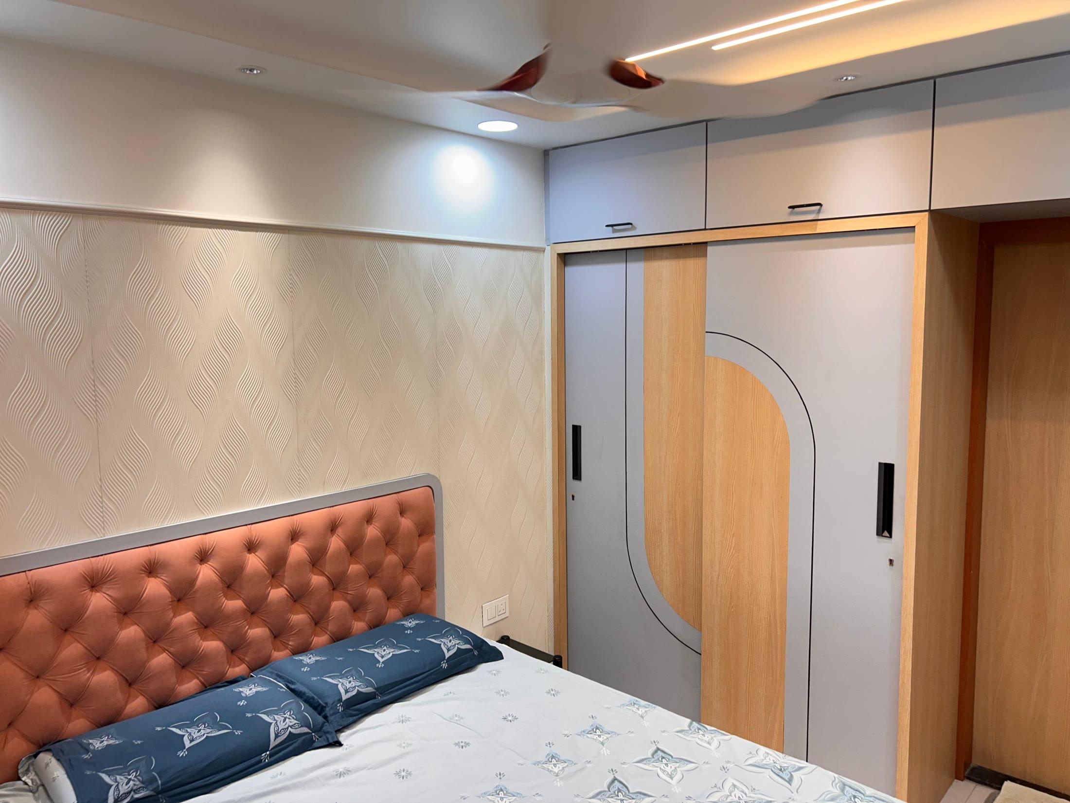 Bedroom with the tufted headboard beside a curved-shutter wardrobe