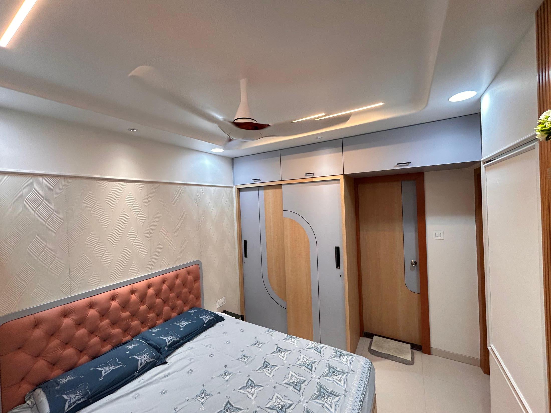 Bedroom seen wide, with the wardrobe wall and bedroom door