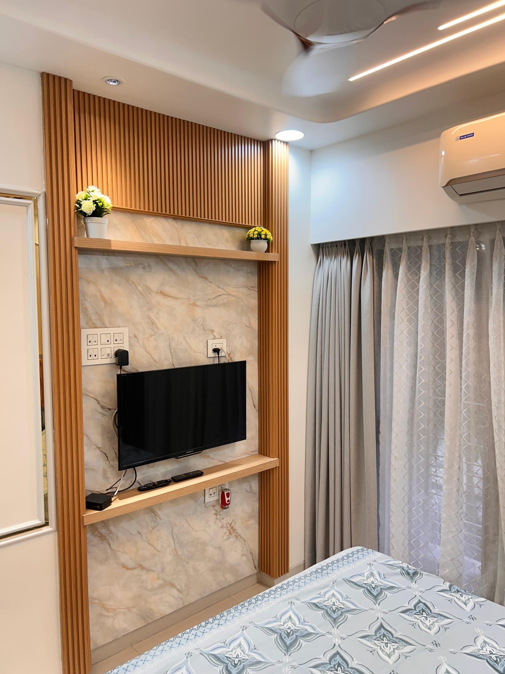 Bedroom television panel in fluted teak and marble with a floating shelf