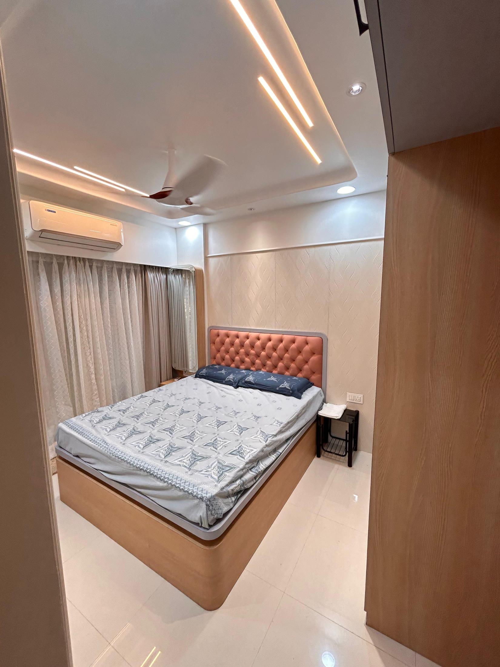 Bedroom with the bed alongside the teak-edged wardrobe